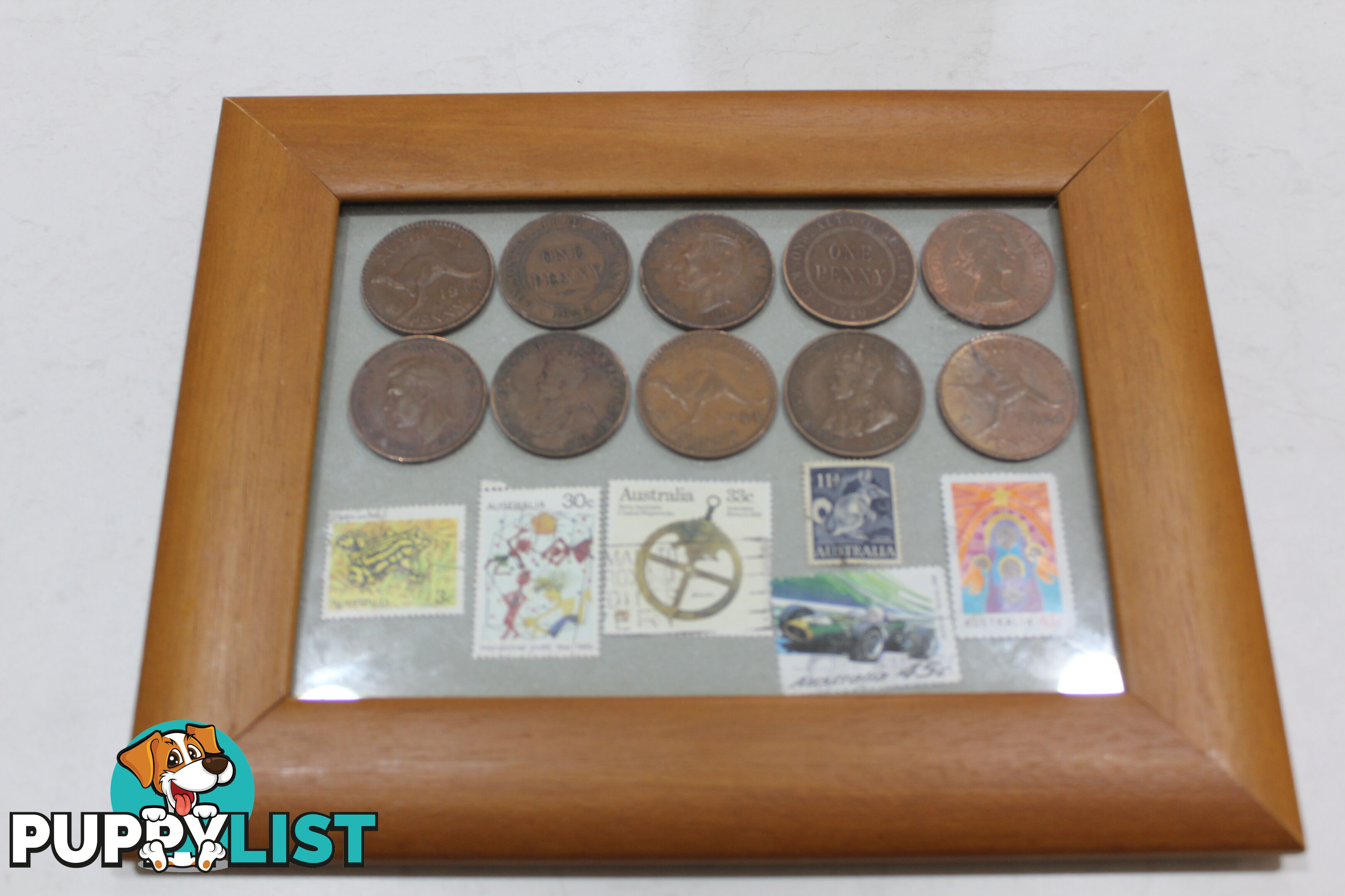 Penny&amp;#39;s and old stamps in picture frame